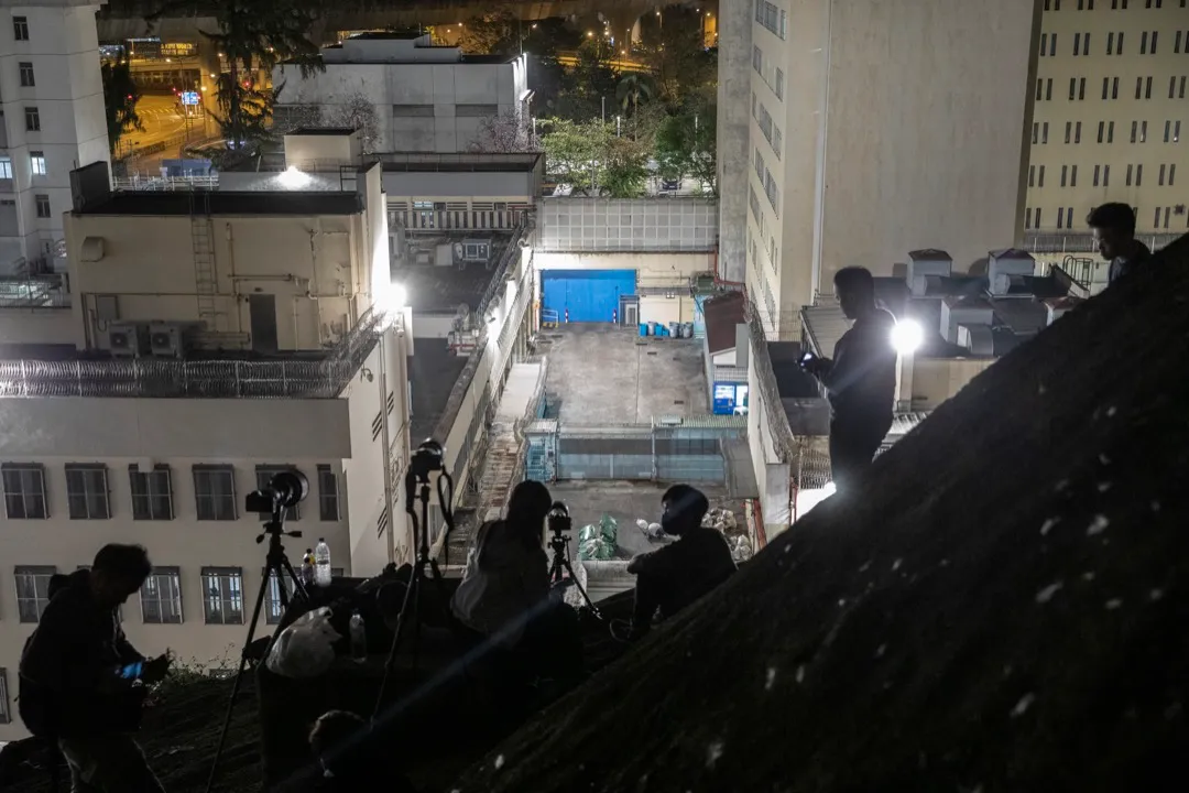2021年3月2日凌晨,一眾攝影記者在山坡上等候拍攝被押解到荔枝角收押所的被告。攝:林振東/端傳媒